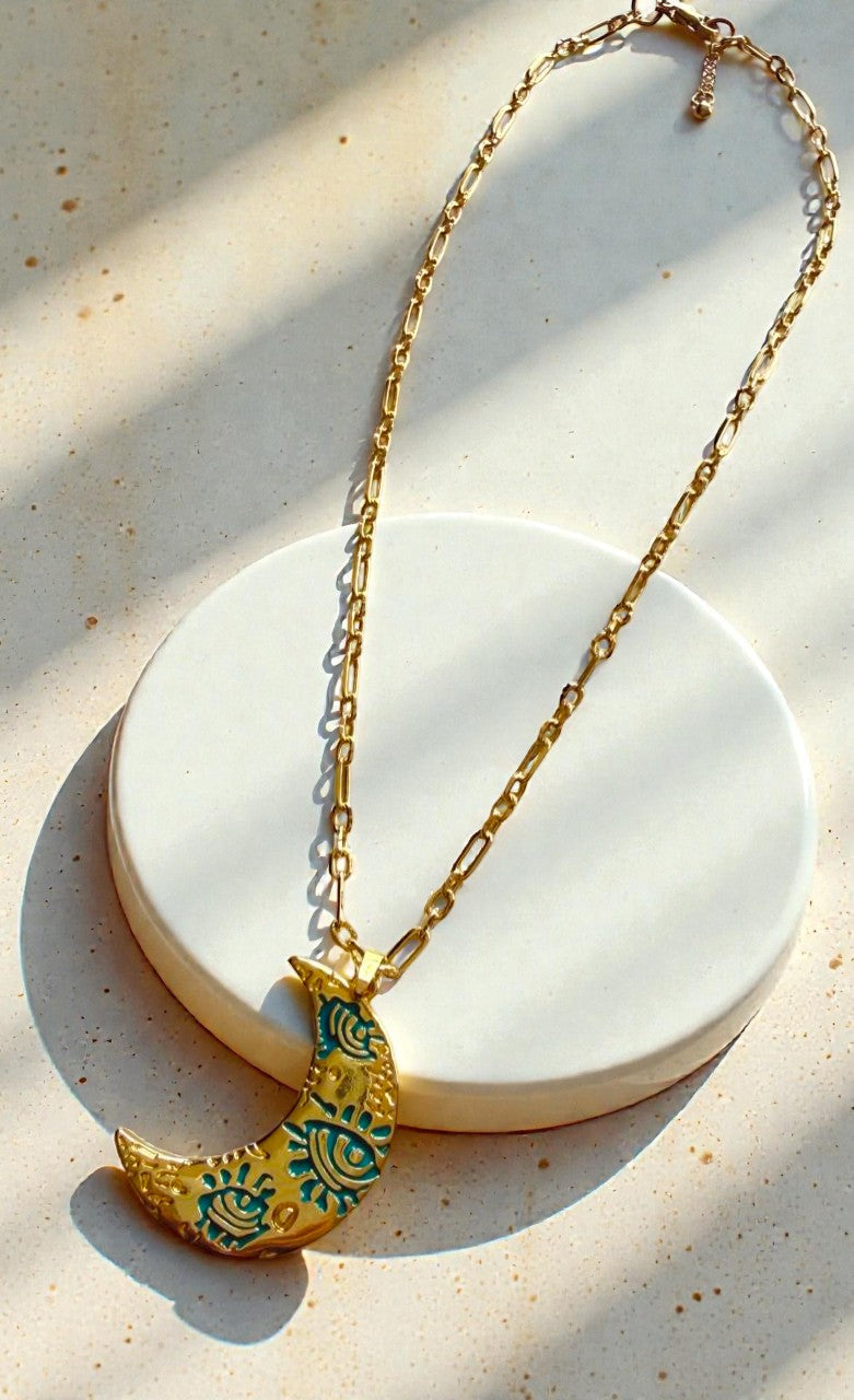 Collar de cadena dorada con luna decorativa.